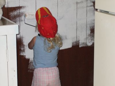 A Kid Painting Over Wall Paneling